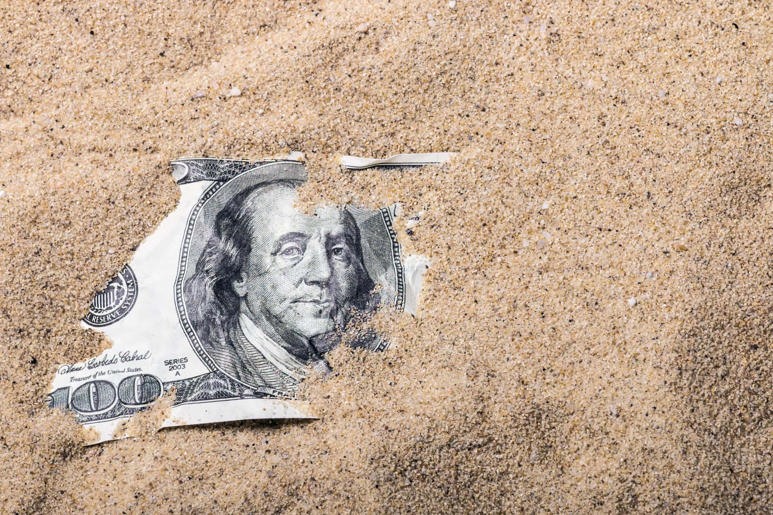 US-Dollar Note von Sand bedeckt