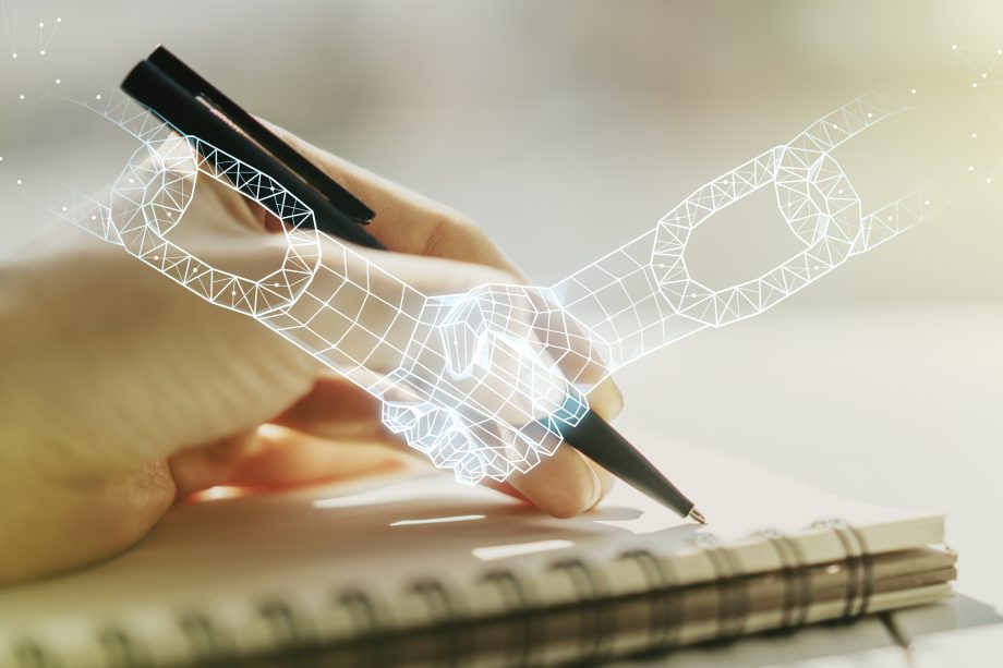 Bildung mit Blockchain: Die ersten Gehversuche und was noch möglich ist Eine Hand schreibt mit Kugelschreiber in ein Notizbuch