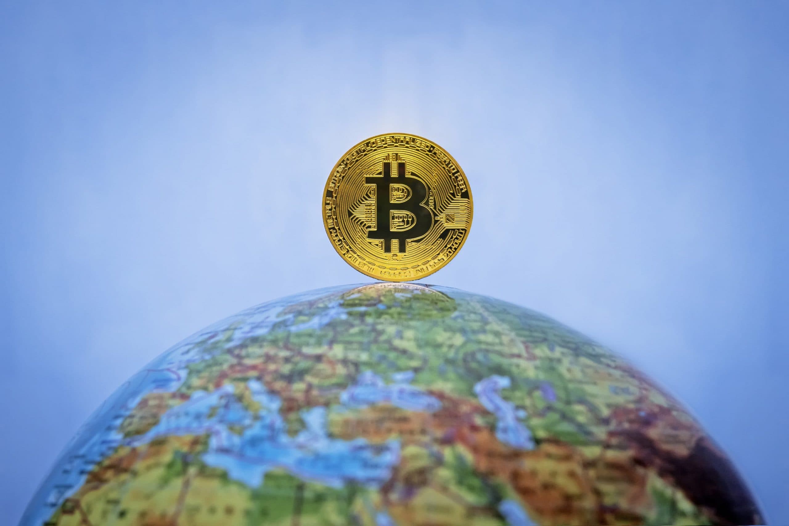 Bitcoin-Münze auf dem Nordpol eines Globus