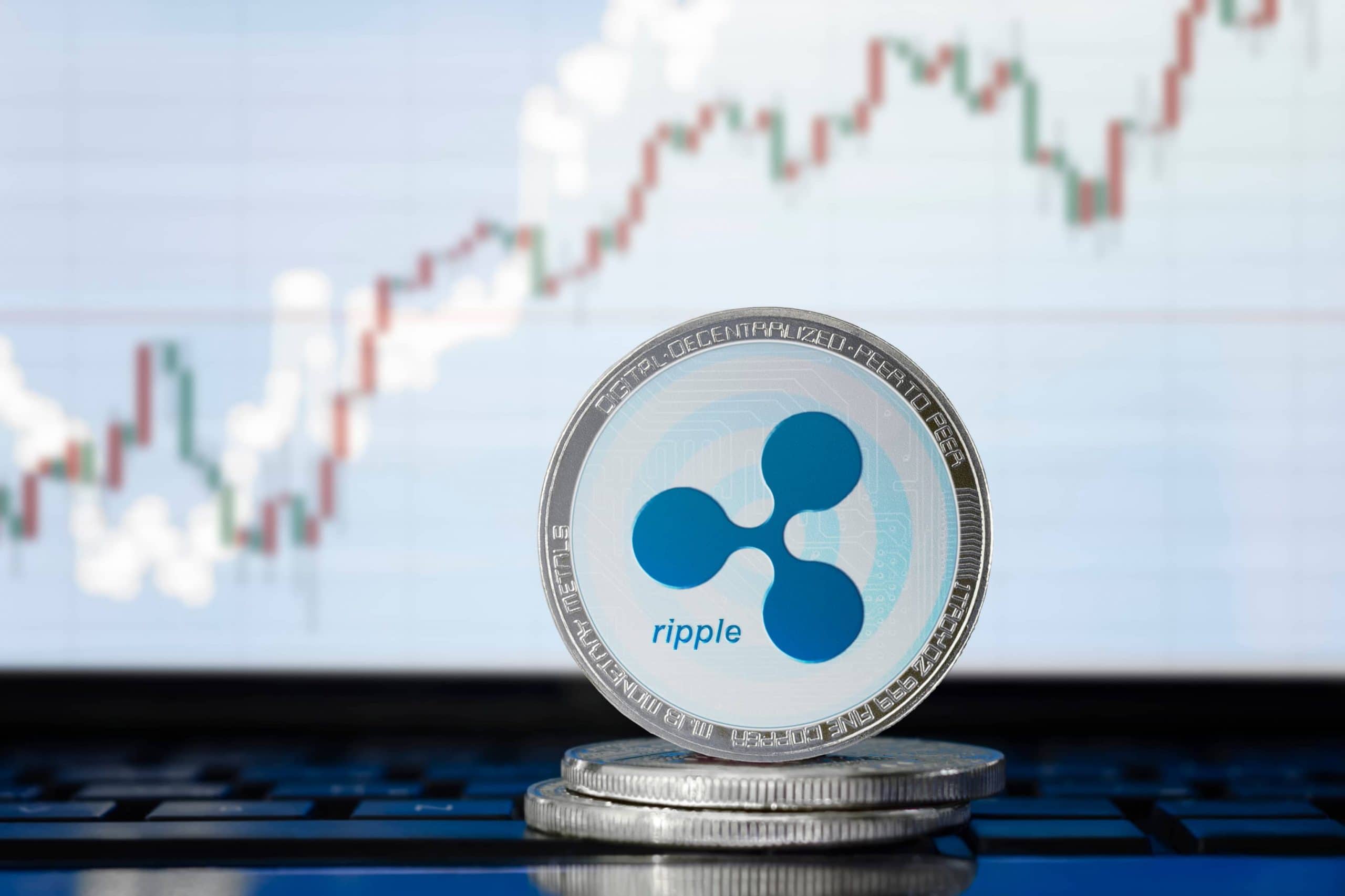 RIPPLE (XRP)-Kryptowährung; physikalische Concept-Rippelmünze auf dem Hintergrund des Diagramms