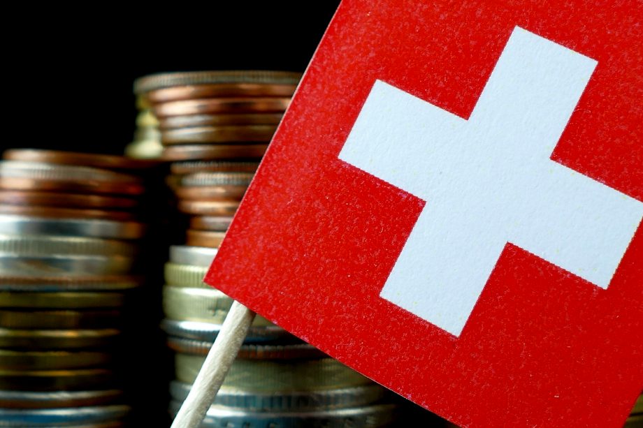 CBDC in der Schweiz: Projekt Helvetia meldet erste Erfolge Kleingeldstapel und Schweizer Nationalflagge für CBDC Projekt