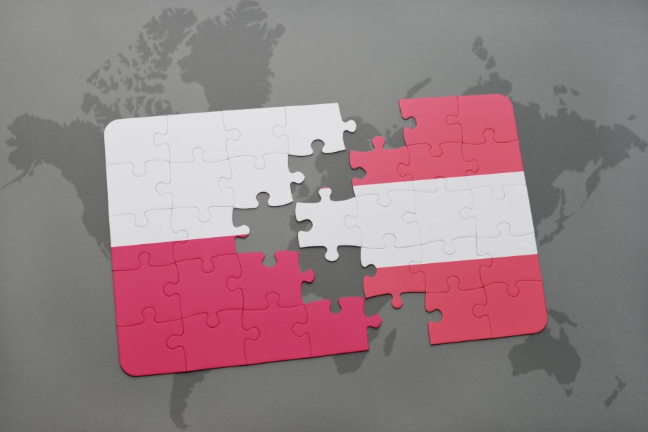 Bitpanda schafft hunderte Arbeitsplätze durch Technologiezentrum in Polen Zusammenpassende Puzzle-Teile in den Farben Östereichs und Polen,
