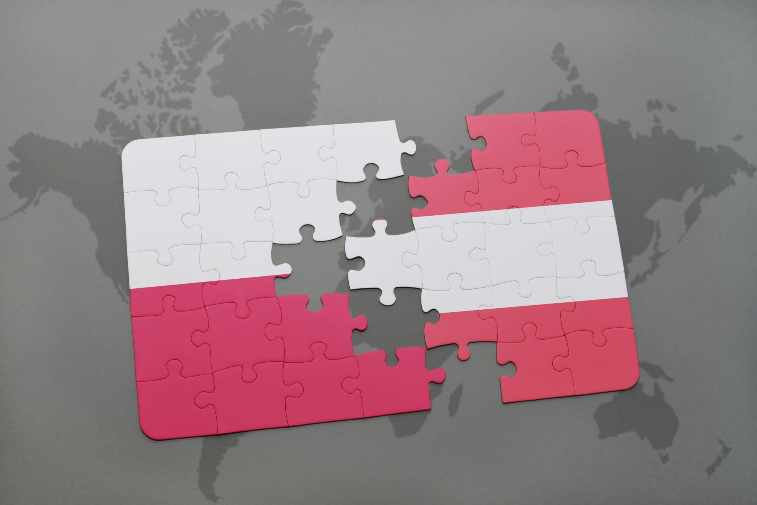 Zusammenpassende Puzzle-Teile in den Farben Östereichs und Polen,