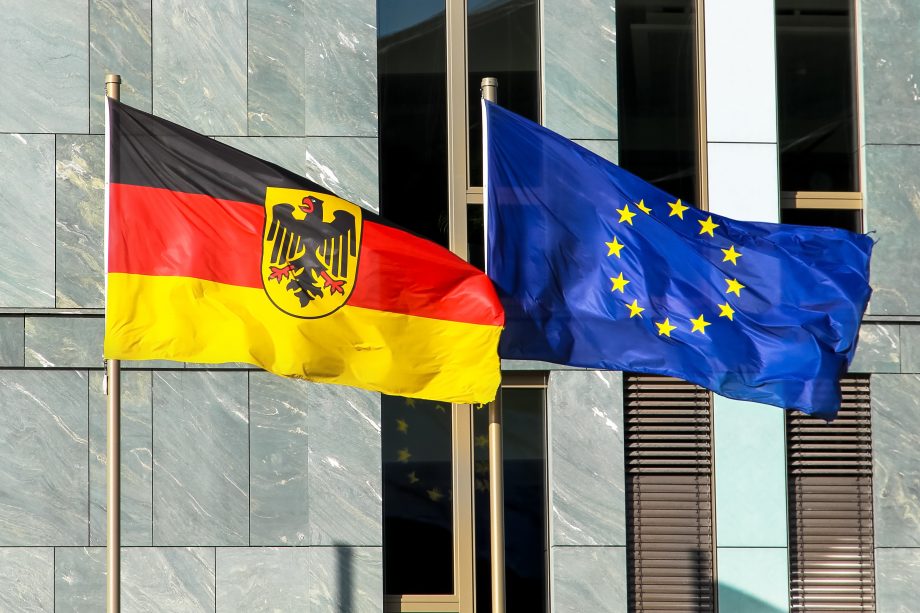 Kein Fortschritt: Bunderegierung zögert bei E-Euro Deutsche und europäische Flagge wehen vor einem Gebäude.
