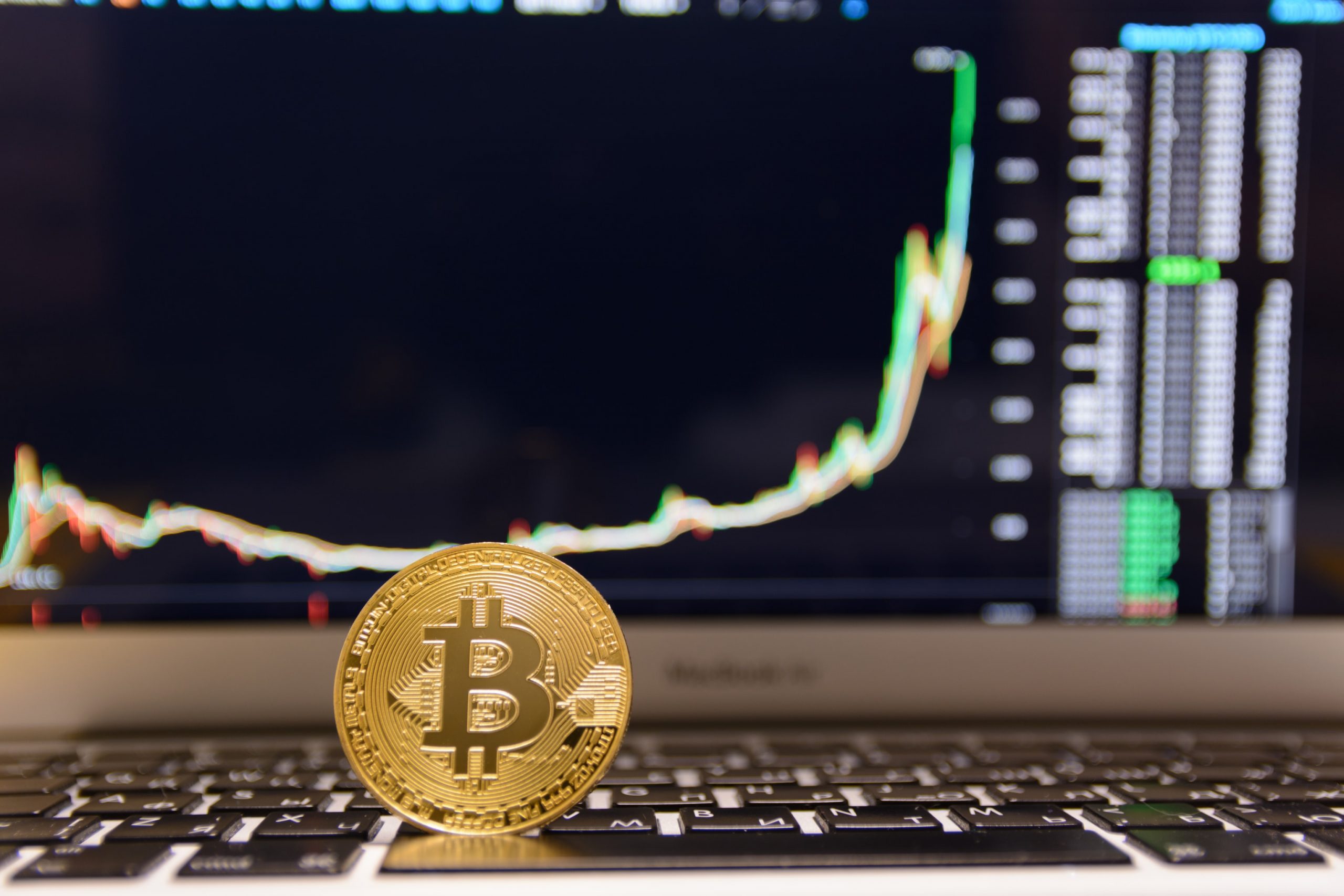 Bitcoin-Münze vor Chart mit BTC-Kurs