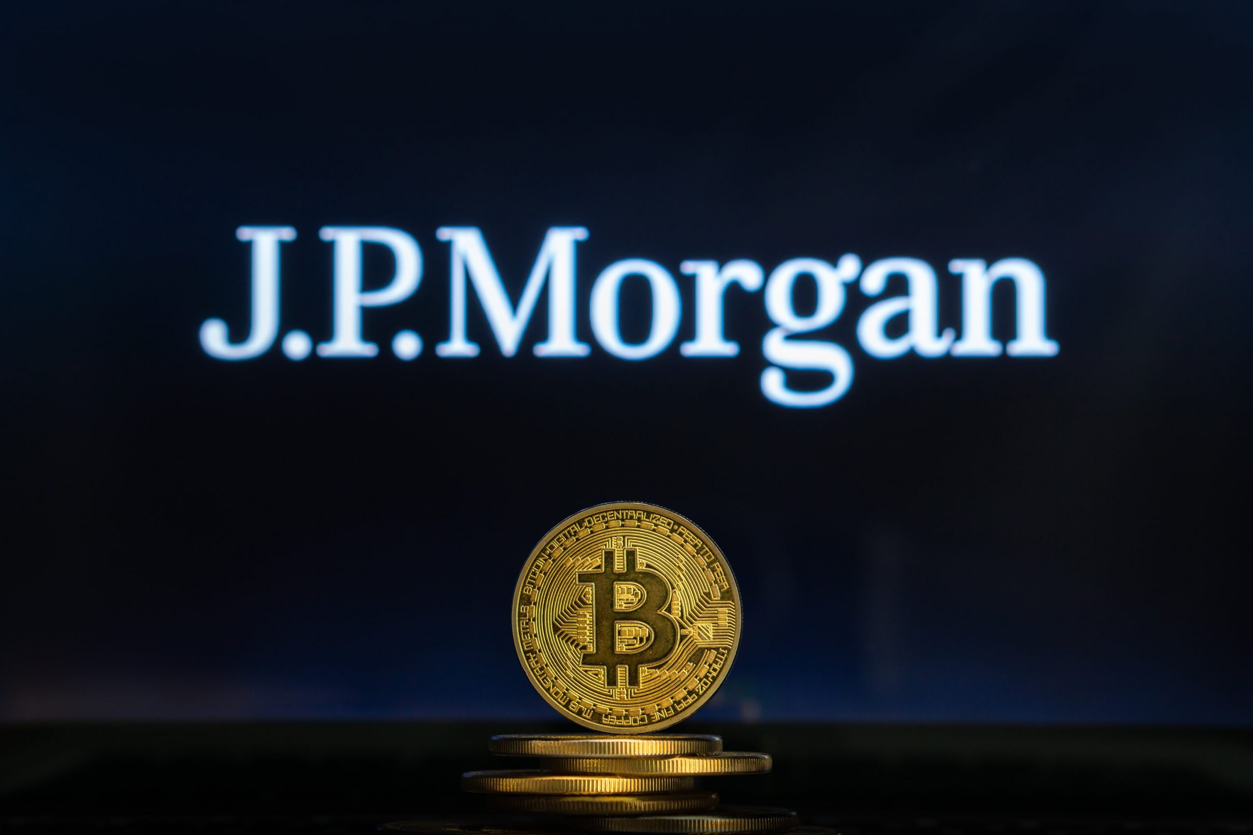 Bitcoin-Münze vor einem JPMorgan-Schriftzug