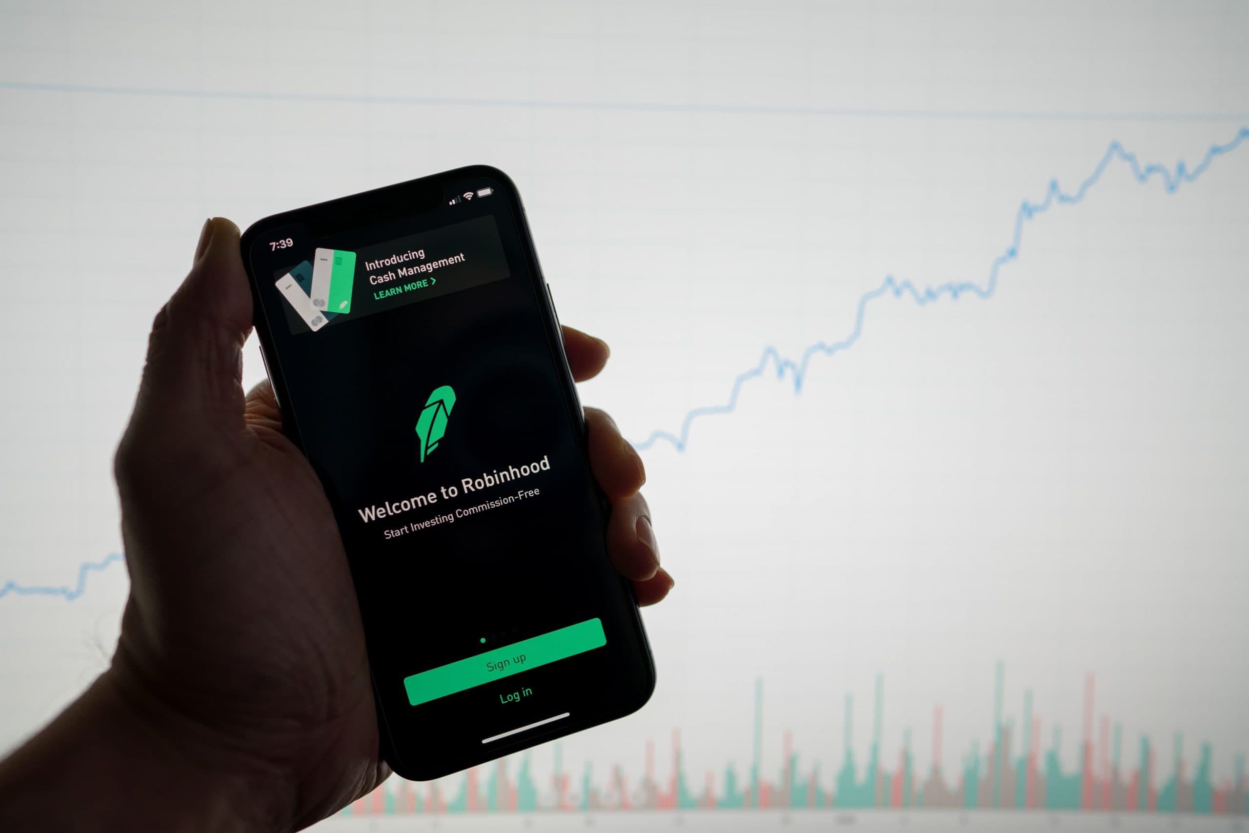 Die Tradig-App Robinhood, dahinter ein Börsen-Chart