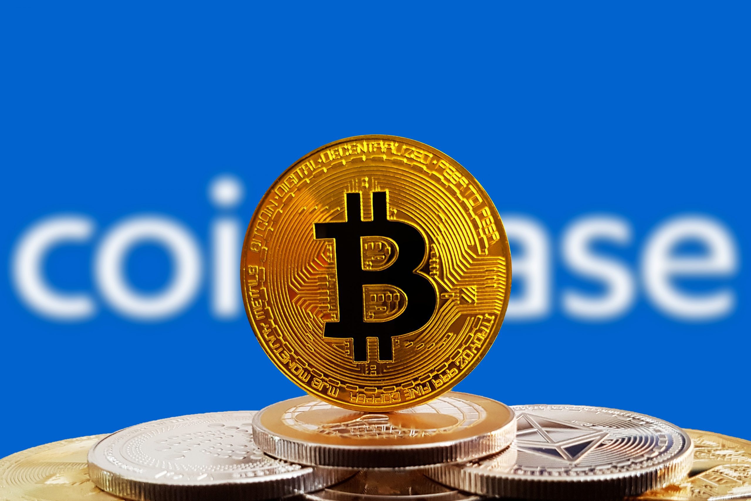 Bitcoin-Münze vor Coinbase-Logo