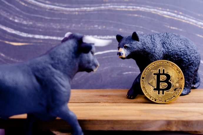 Bitcoin-Münze zwischen Bär- und Bullen-Figur