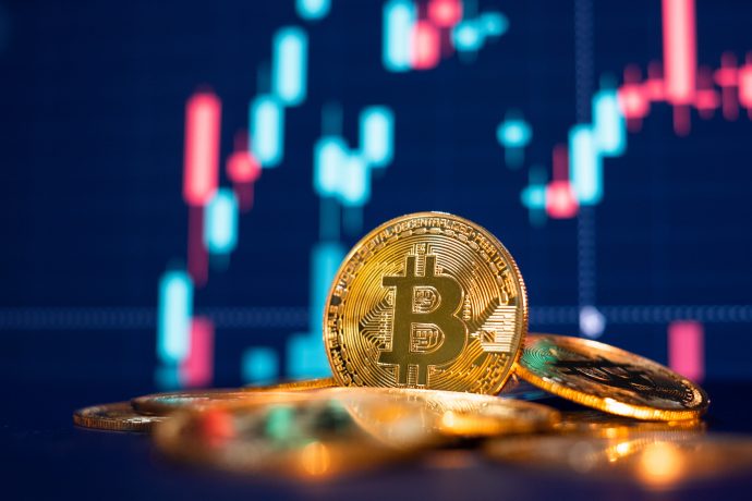 Bitcoin-Münze liegt vor einem Chart