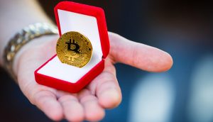 Bitcoin-Münze, präsentiert in in einer Ring-Schachtel