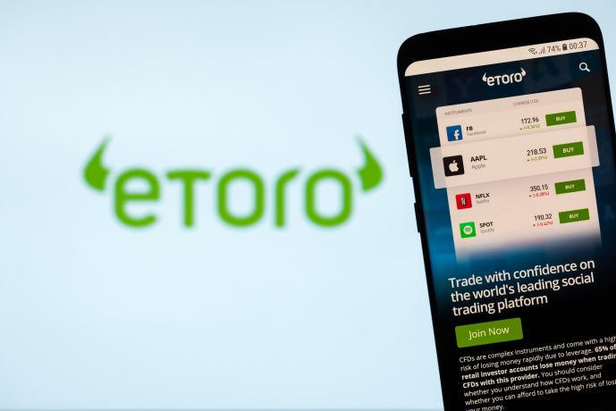 Smartphone vor eToro-Logo