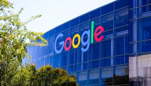 Das Firmenlogo von Google an einer gläsernen Gebäudefassade.