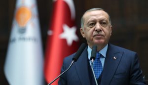 Der türkische Präsident Erdogan steht vor einem Rednerpult. Dahinter sieht man die türkische Flagge.