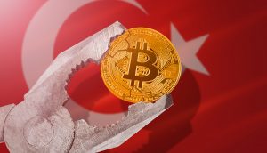 Bitcoin-Münze in Schraubzwinge vor türkischer Flagge