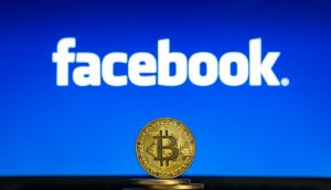Bitcoin-Münze vor Facebook-Logo