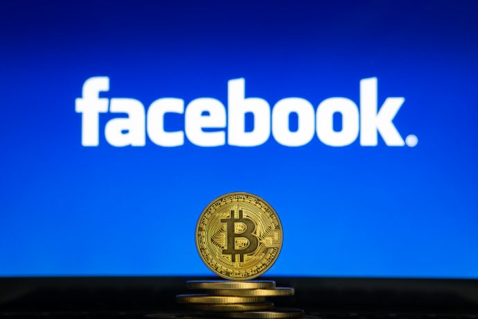 Bitcoin-Münze vor Facebook-Logo