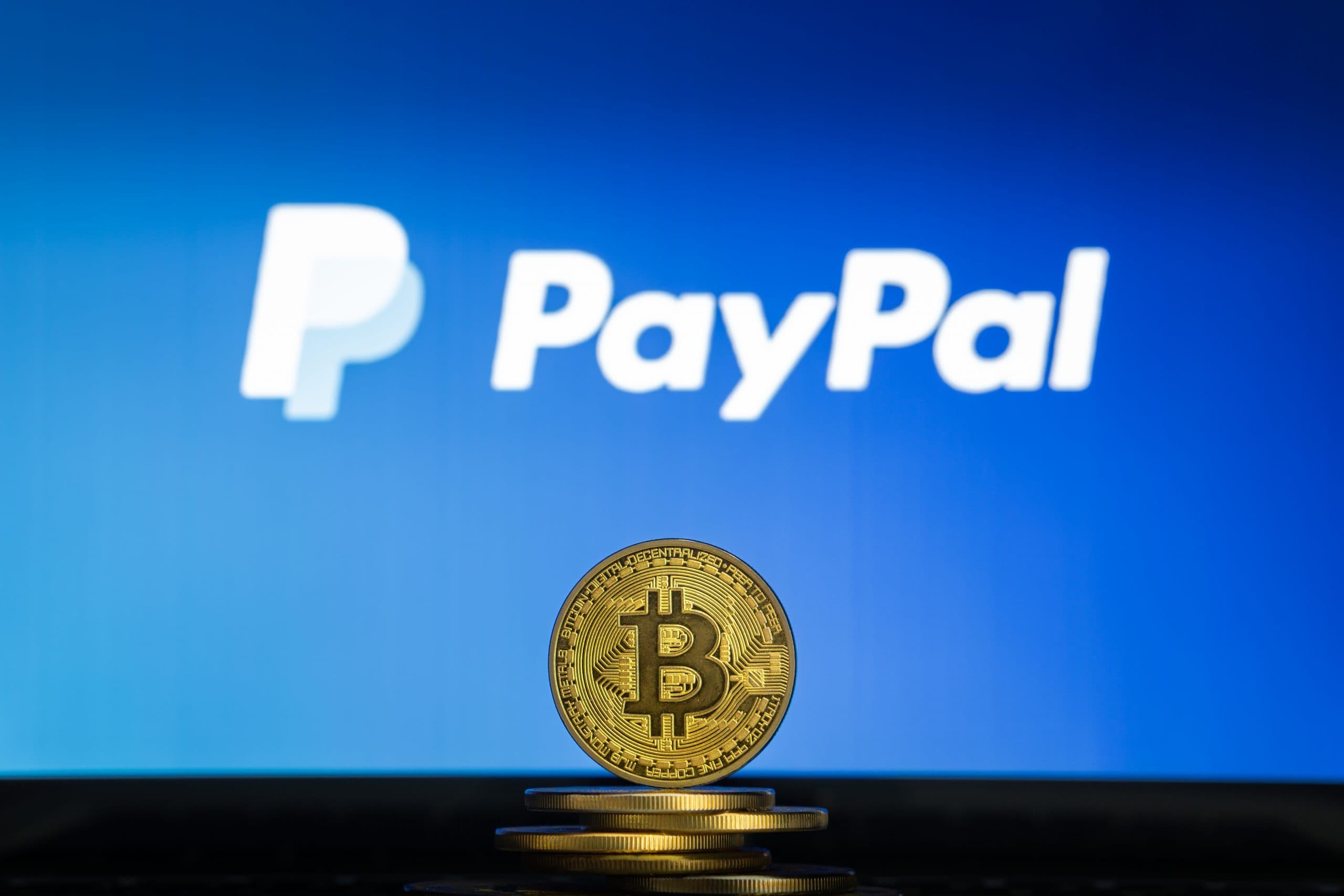 Bitcoin-Münze vor PayPal-Logo