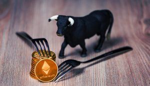 Stapel mit Ethereum-Münzen, daneben eine Bullenfigur und Gabeln (Symbolbild Berlin hard Fork)