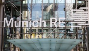 Das Logo der Munich RE vor einer gläsernen Gebäudefassade