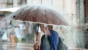 Regen fällt auf einen Regenschirm