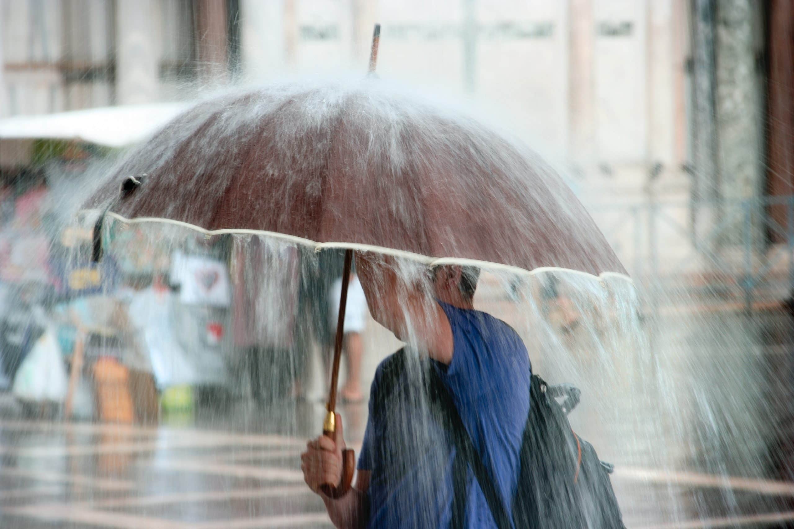 Regen fällt auf einen Regenschirm