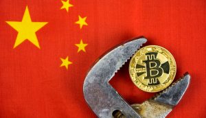 Bitcoin in Rohtzange, im Hitnergrund die chinesische Flagge