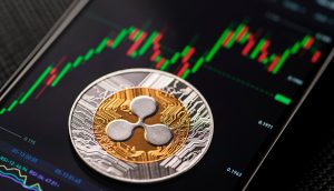 XRP-Münze auf Smartphone, das einen Kurs-Chart zeigt