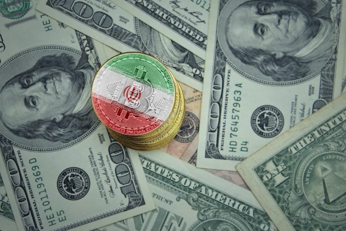 Ein Stapel Bitcoin-Münzen in Irans Farben, dartunter US-Dollarnoten