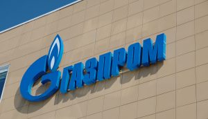 Das Logo von Gazprom in kyrillischer Schrift auf einem braunen Hintergrund.