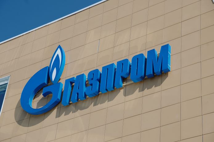 Das Logo von Gazprom in kyrillischer Schrift auf einem braunen Hintergrund.