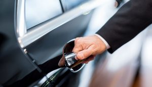 Hand öffnet Autotür
