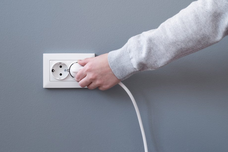 Miner-Shutdown: Bitcoin Hash Rate fällt auf Vorjahresniveau Hand steckt Kabel in Steckdose
