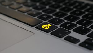 Eine Laptoptastatur, mit einem Geldsacksymbol, worauf das Logo von Binance abgebildet ist.