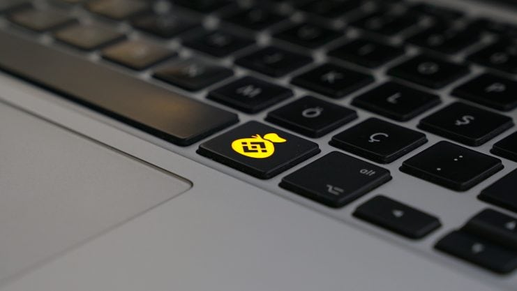 Eine Laptoptastatur, mit einem Geldsacksymbol, worauf das Logo von Binance abgebildet ist.