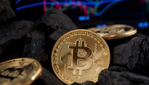 Bitcoin-Münzen und Kohle vor Chart-Hintergrund