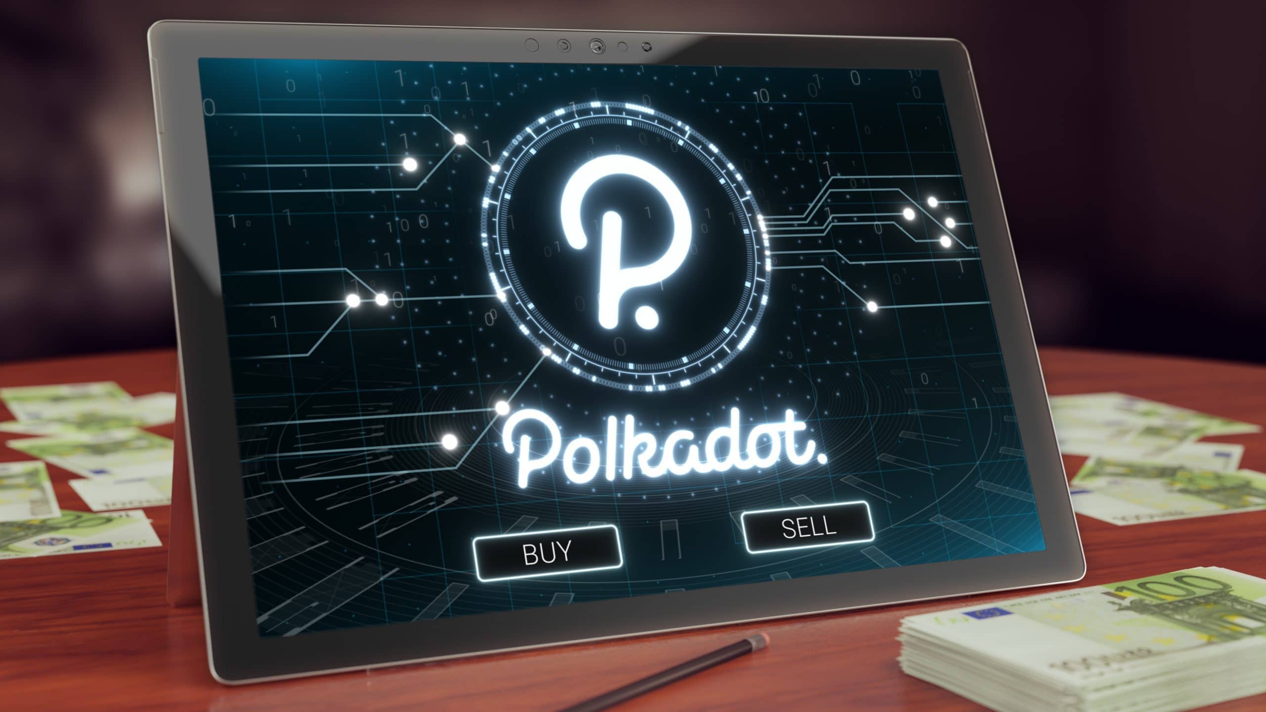 Das Logo von Polkadot auf einem Tablet. Daneben liegen mehrere Bündel 100€-Scheine.