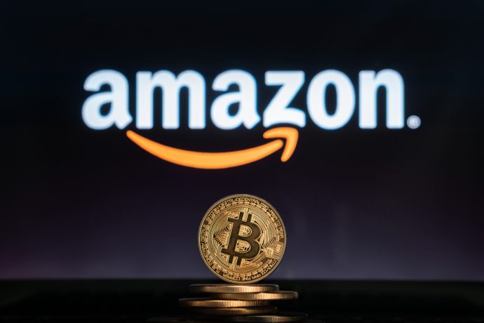 Bitcoin-Münze vor Amazon-Logo