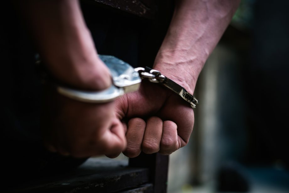 Immobilien und ein Rennpferd: Bitcoin-Betrüger zu 15 Jahren Haft verurteilt Typ in Handschellen