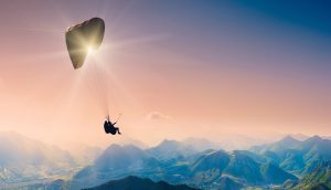 Ein Paraglider fliegt über die Berge