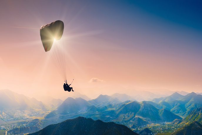 Ein Paraglider fliegt über die Berge