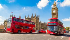 Zwei Busse in London vor der Westminster Abbey und dem Big Ben.