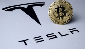 Tesla Logo und Bitcoin-Münze