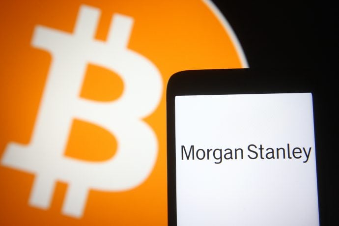 Smartphone mit Morgan Stanley Logo vor Bitcoin-Logo