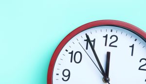 Eine Uhr vor einem türkisen Hintergrund