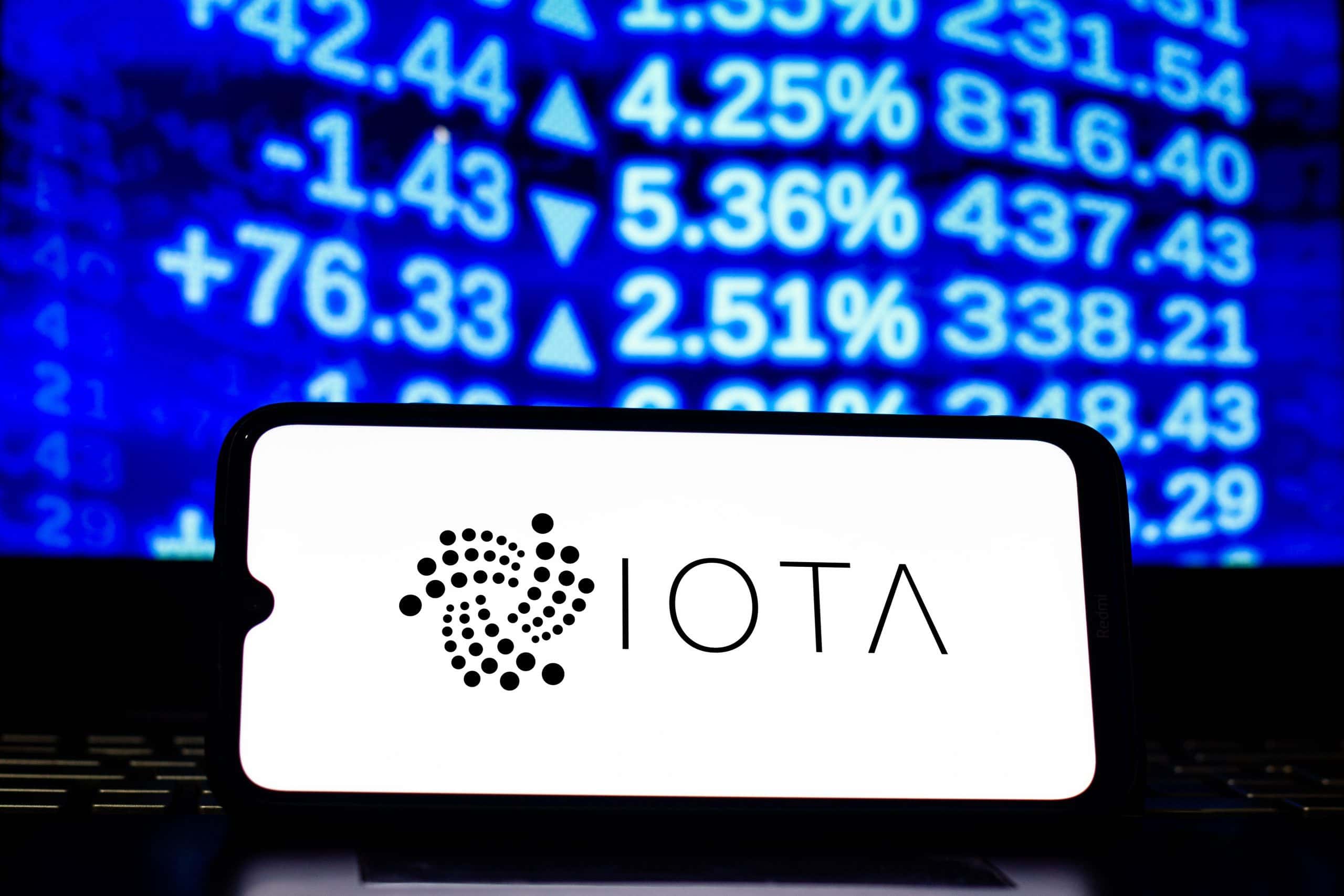 IOTA-Logo auf Smartphone vor Kurs-Ticker.