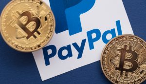 Zwei Bitcoin-Münzen neben dem PayPal-Logo