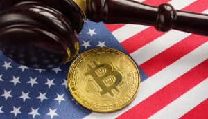 Richterhammer liegt neben Bitcoin-Münze auf der US-Flagge.