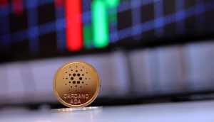 Eine Cardano-Münze steht vor einem Candle Chart.