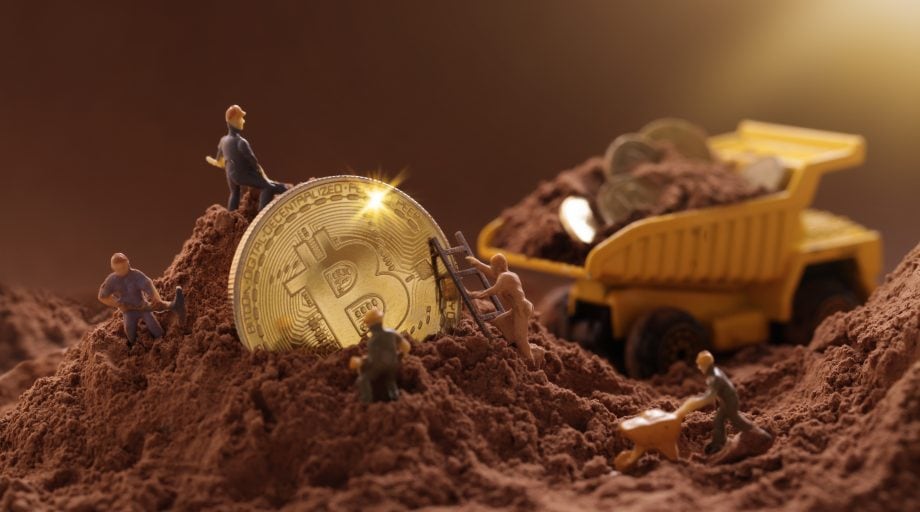 Im Mining-Rausch – Riot Blockchain mit beindruckenden Quartalszahlen Bitcoin Münze wird von kleinen Figuren ausgegraben